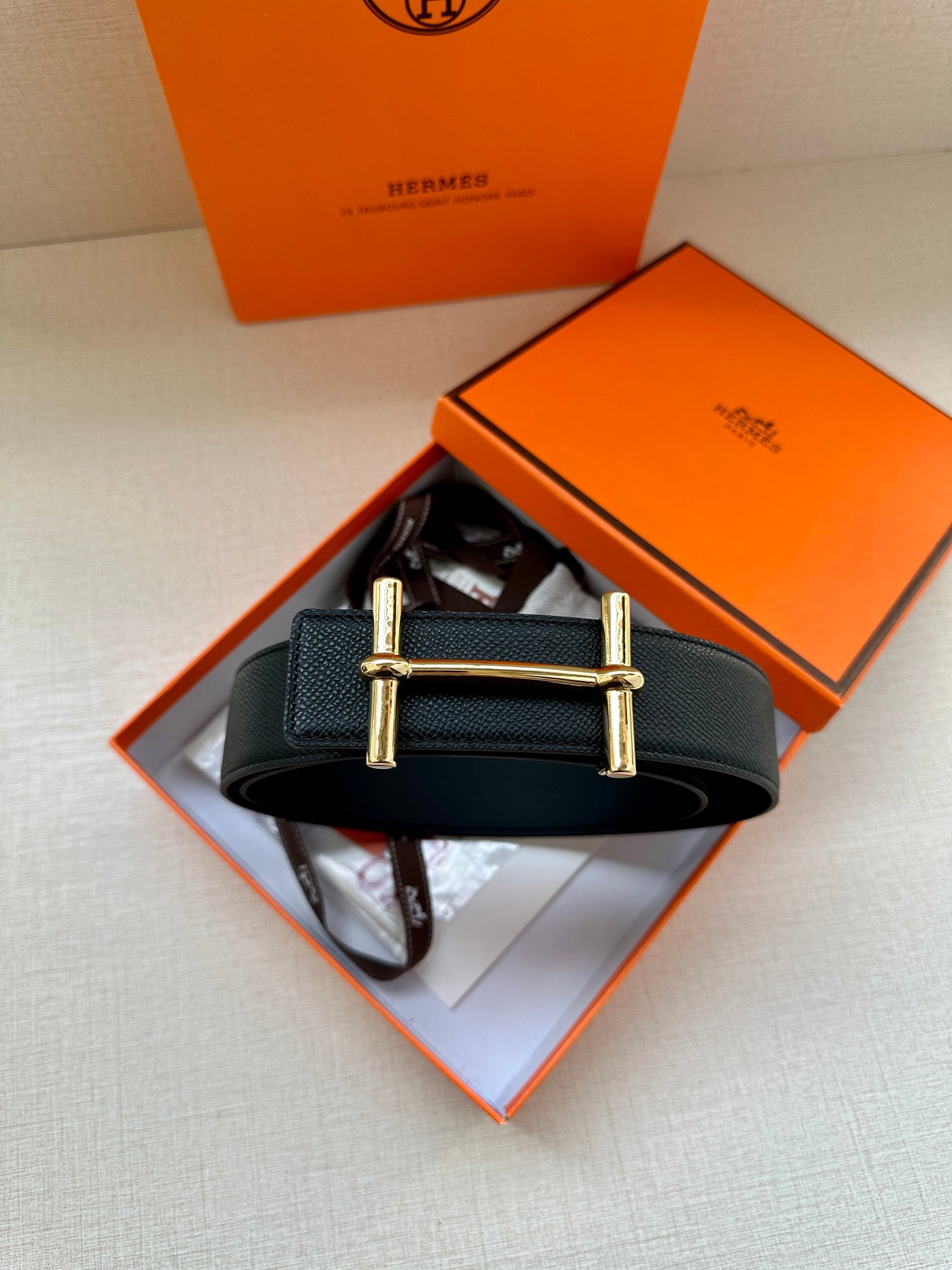 Black leather belt with gold square buckle, flat strap for fastening
