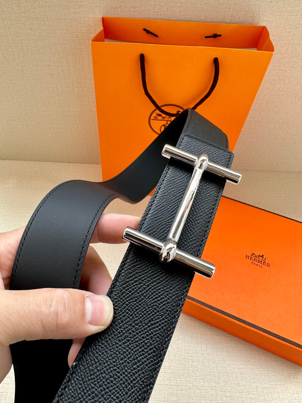 Black leather belt with silver rectangular buckle, textured grain finish