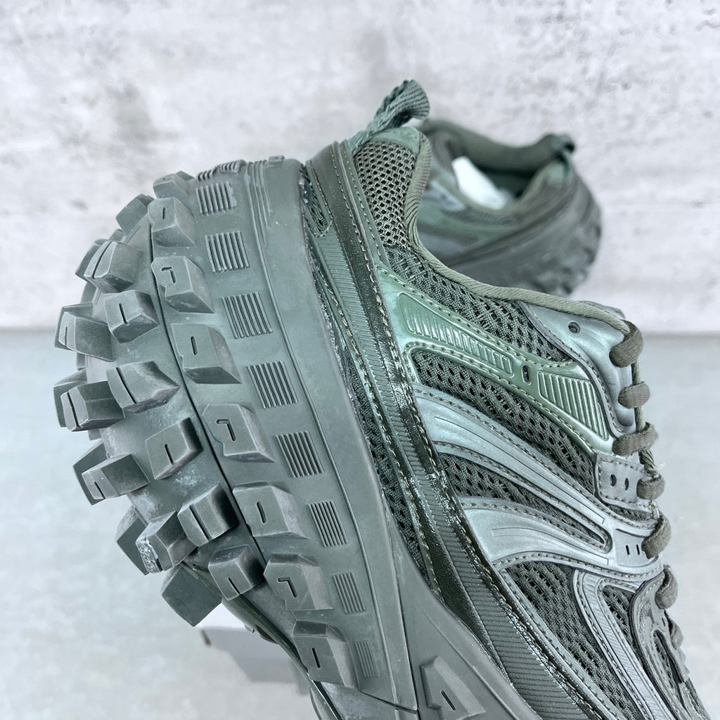 Balenciaga unisex trail shoe side view with rugged lug outsole and perforated upper, muted green.