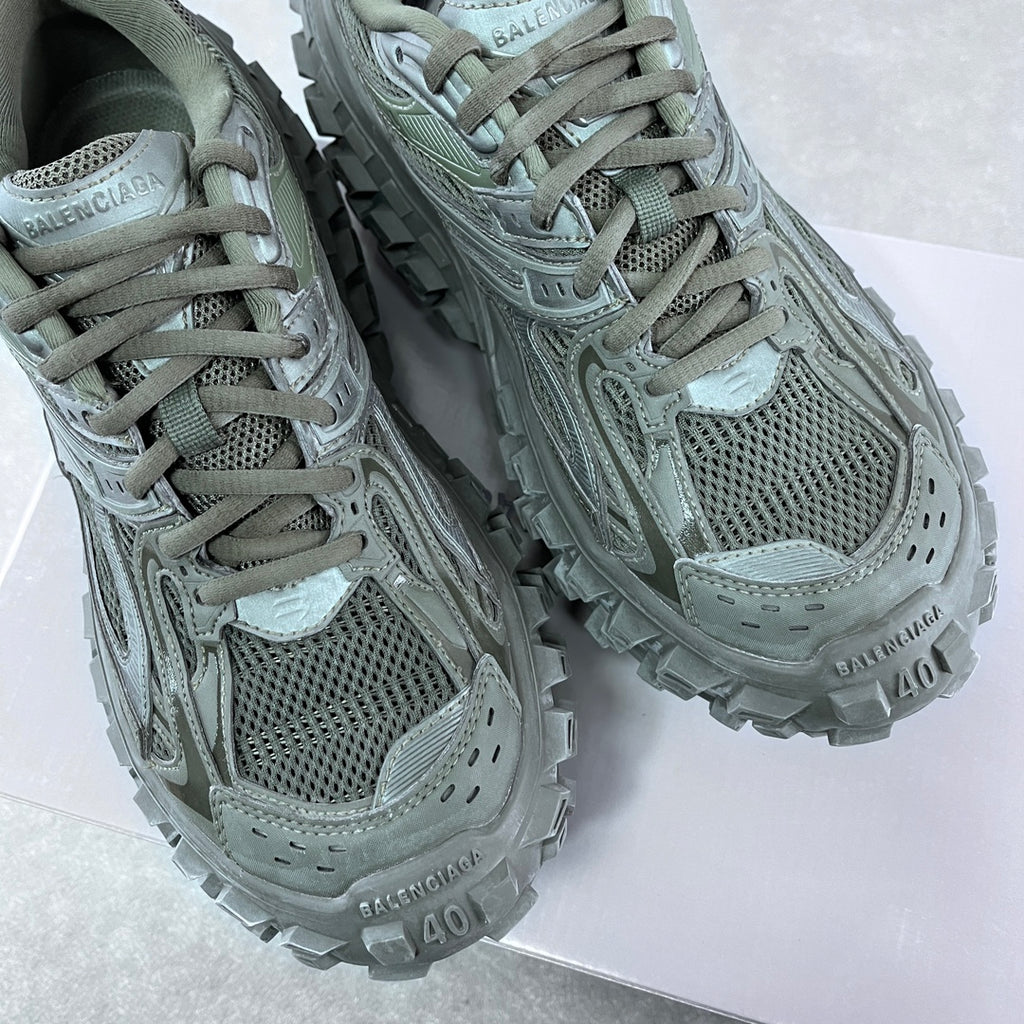 Balenciaga unisex trail shoes with lace-up mesh uppers and textured overlays, muted green.