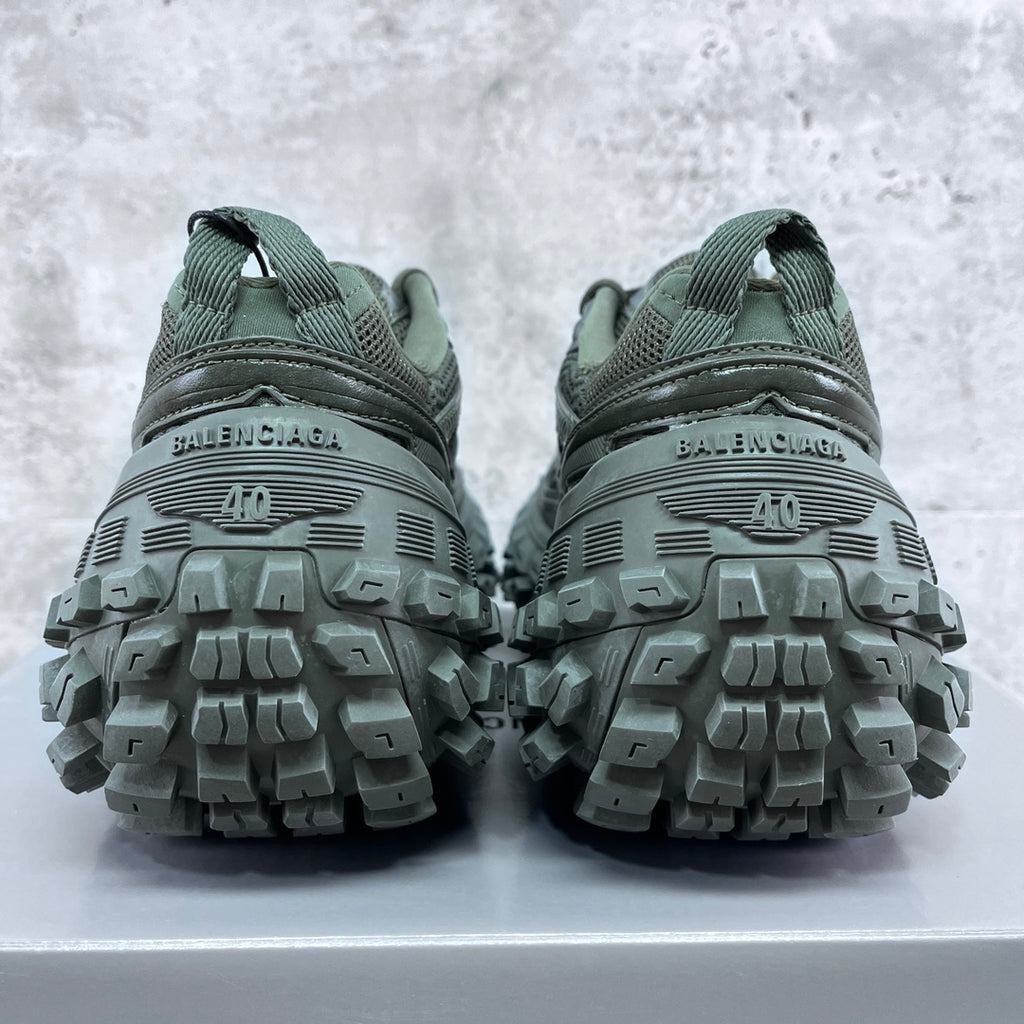 Balenciaga unisex trail shoes rear view with grippy lug soles, muted green.