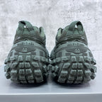 Balenciaga unisex trail shoes rear view with grippy lug soles, muted green.