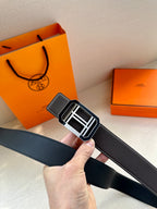 Black leather belt with textured grain and silver-tone rectangular buckle