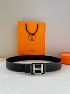 Black leather belt laid flat with silver-tone rectangular buckle
