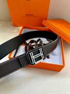 Black leather belt featuring a large silver-tone rectangular buckle