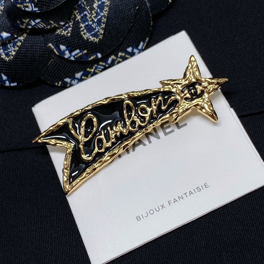 Gold-tone Chanel logo brooch with star ends on Bijoux Fantaisie card