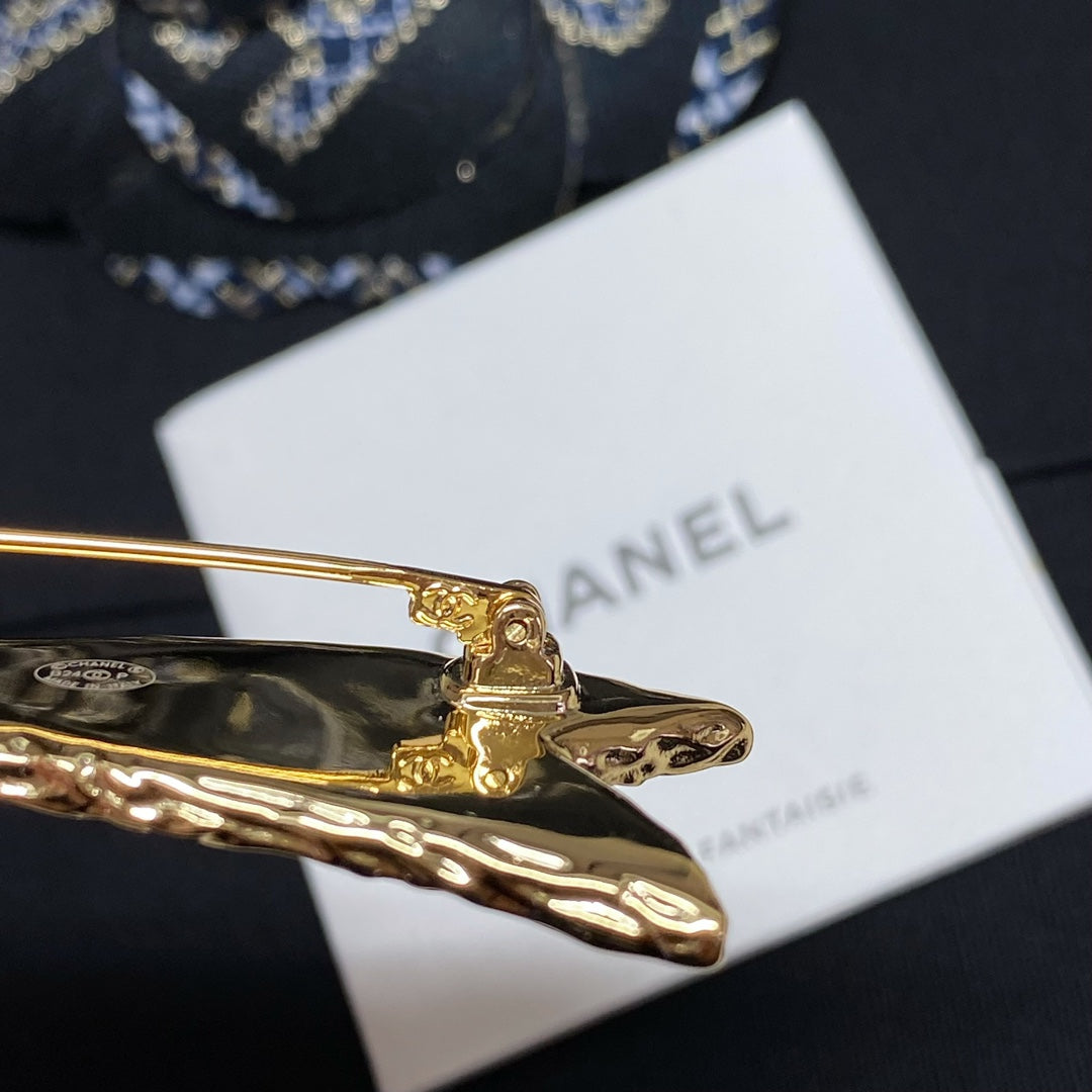 Gold-tone star brooch on Bijoux Fantaisie card, front bar and pin detail