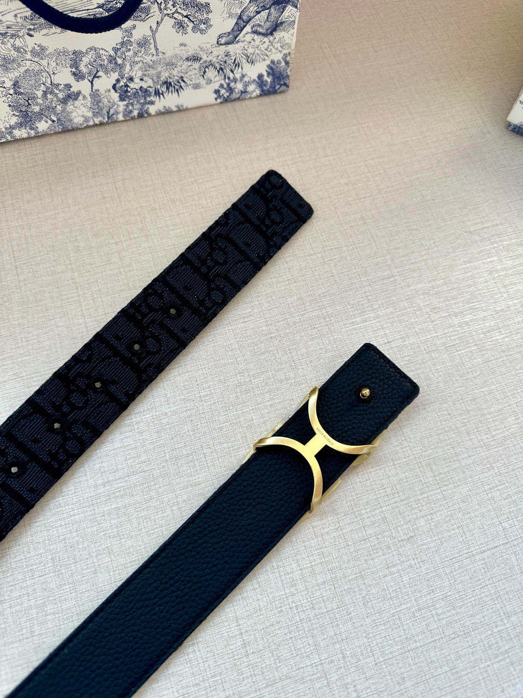 Navy belt with CD gold-tone buckle, studded holes and monogram print.
