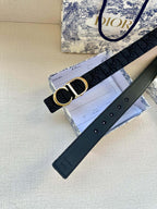 Navy leather belt with CD gold-tone buckle and strap keeper.
