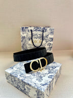Navy leather belt with CD gold-tone buckle on monogram strap.