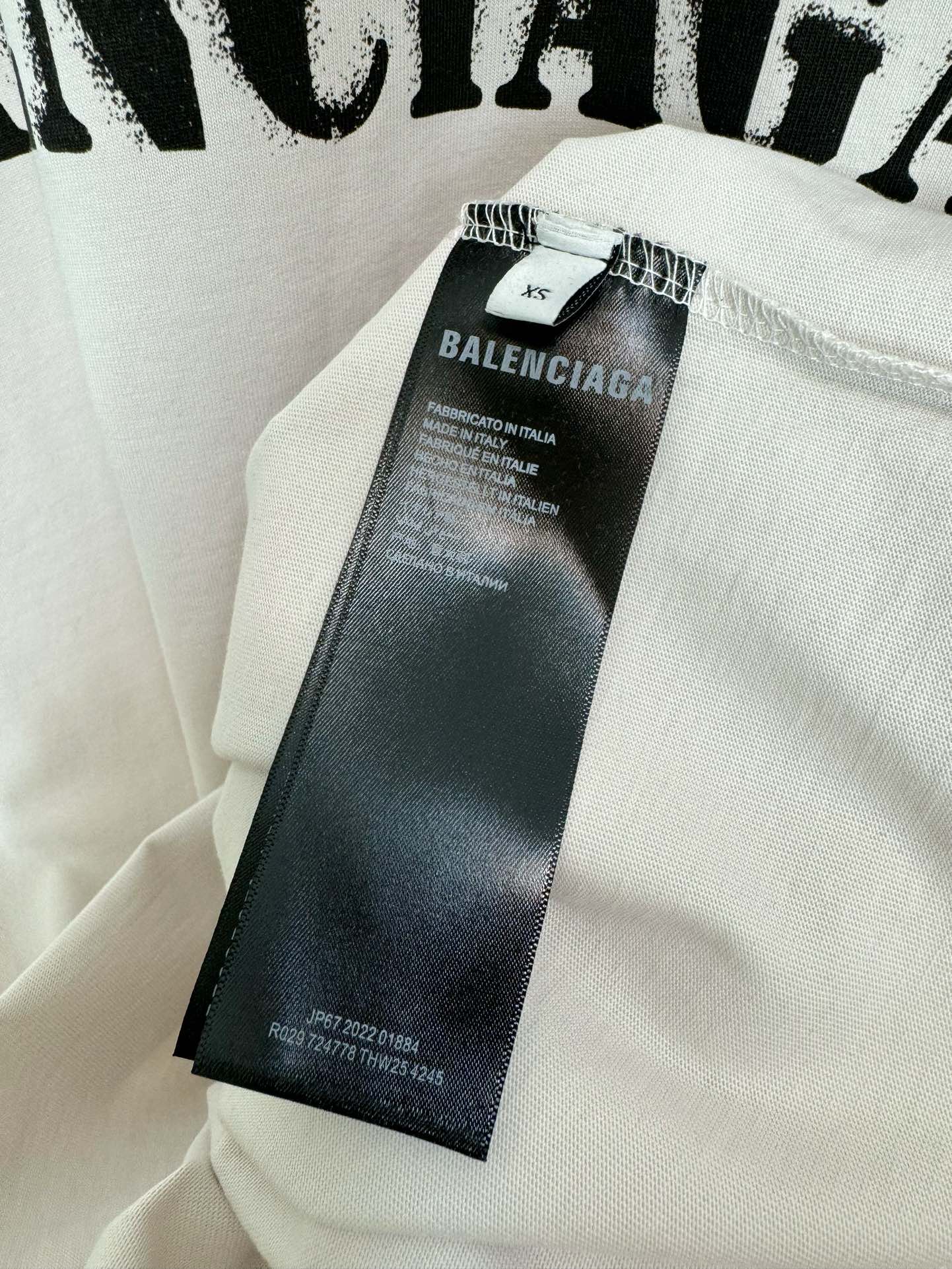 White T-shirt fabric with attached brand label tag at the neckline