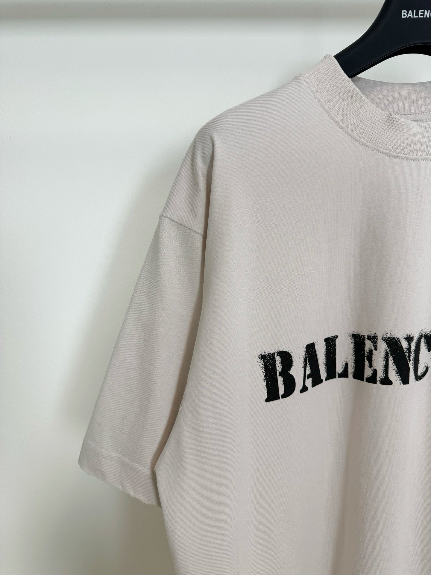 White short-sleeve T-shirt with black BALENCIAGA logo partially visible on the side