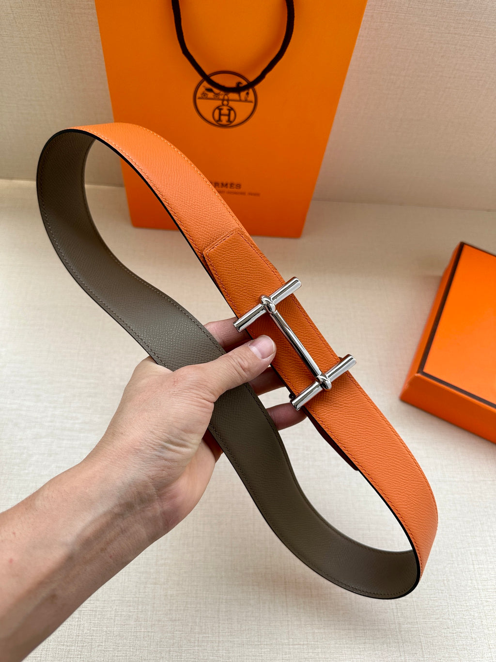 Hermes two-tone belt: orange leather front, dark lining, silver buckle