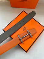 Hermes leather belt with orange underside, dark strap, silver bar buckle