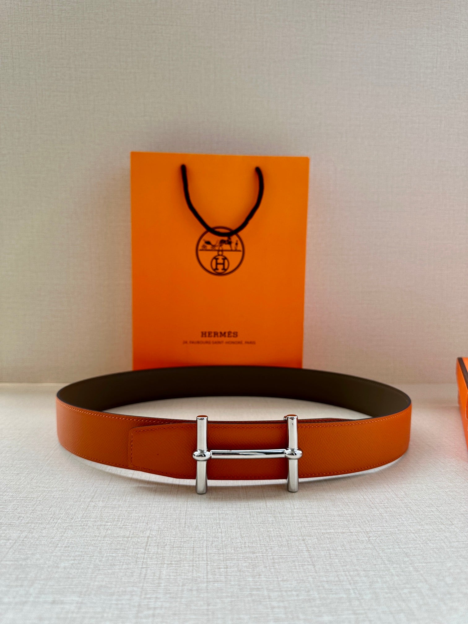 Hermes orange leather belt with silver buckle and dark strap back