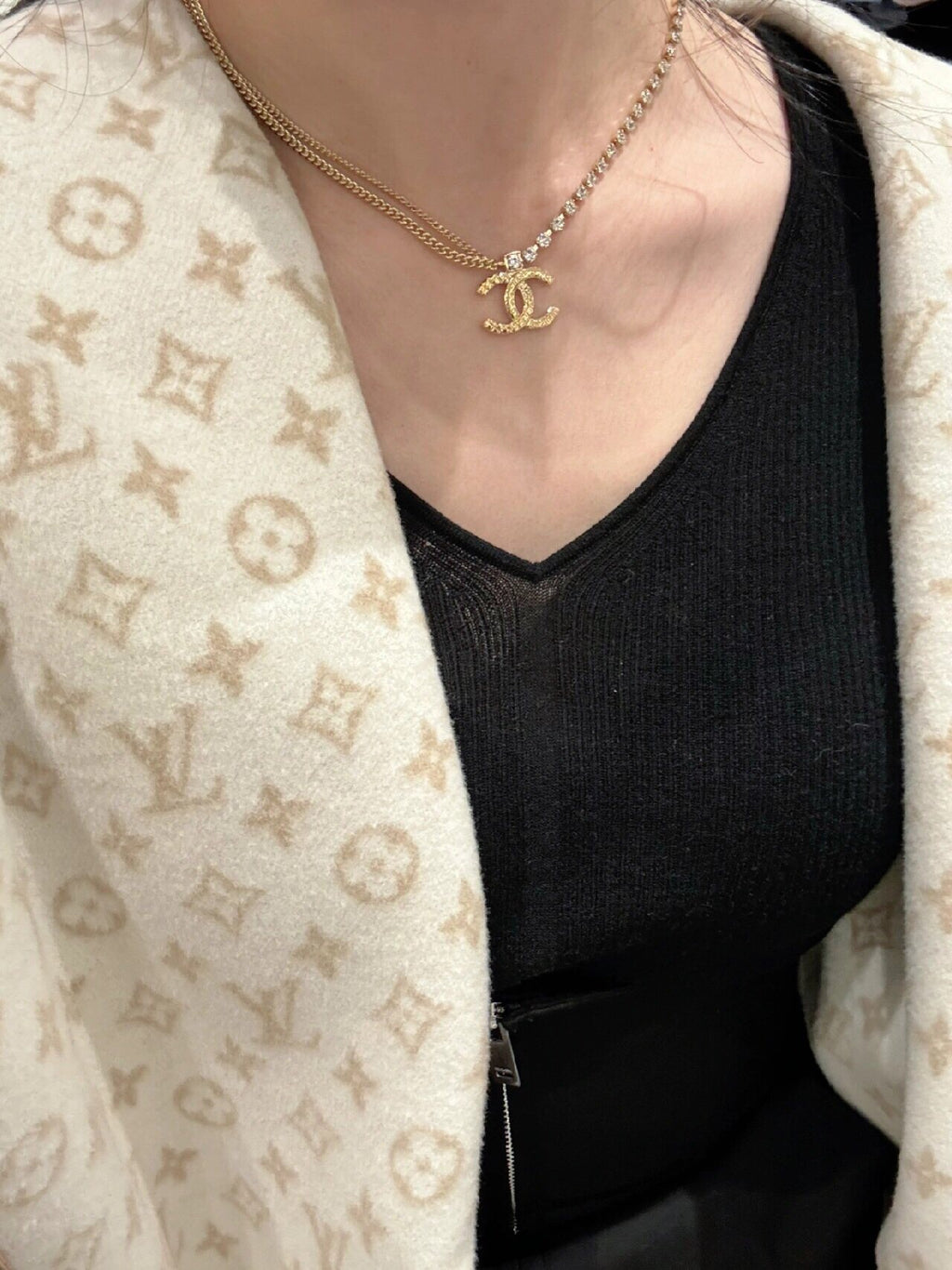 Gold-tone chain necklace with Chanel logo pendant, on black V-neck top