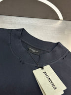 Dark blue crewneck T-shirt with inner neck label and hanging price tag.