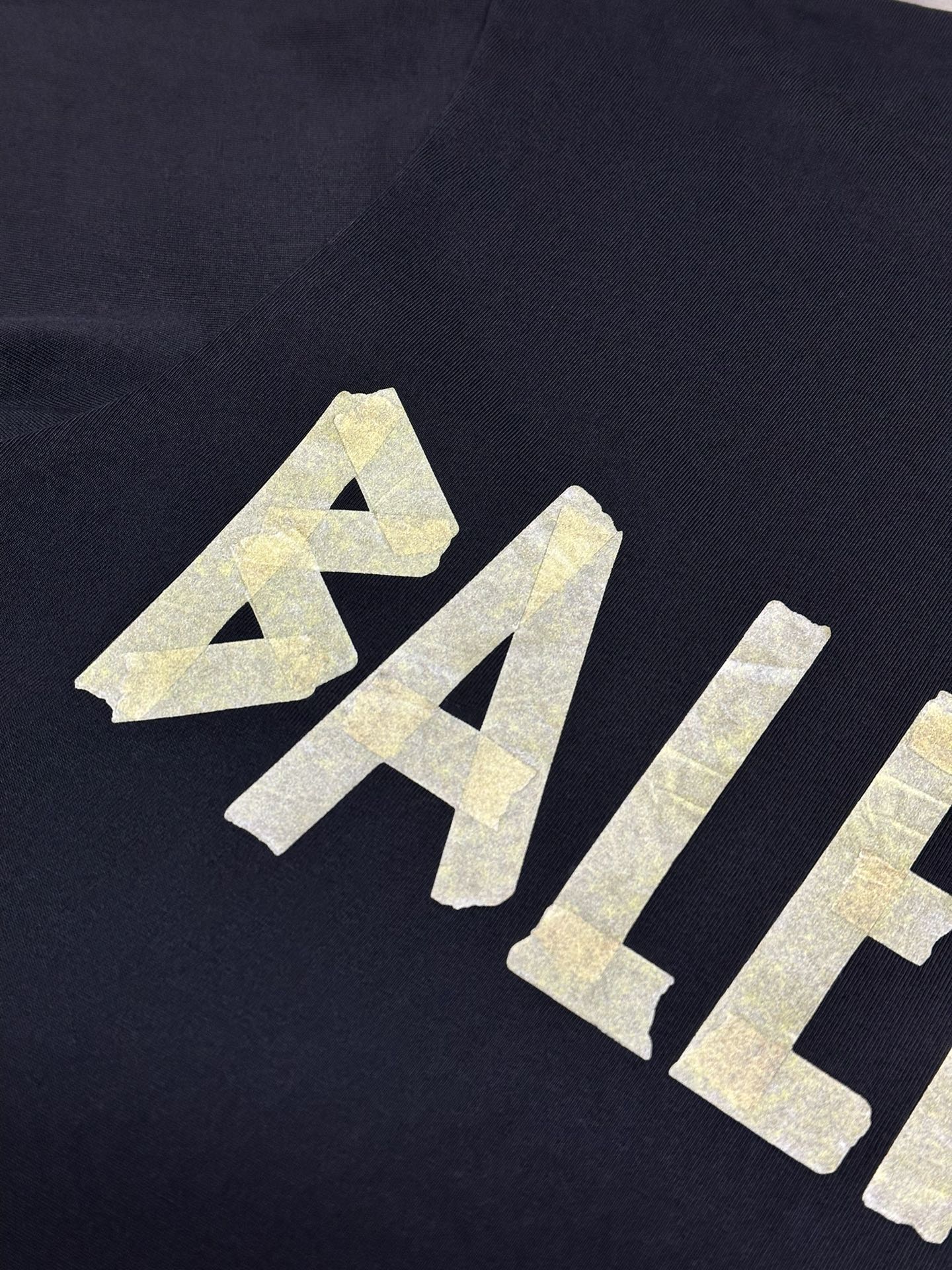 Dark blue T-shirt with textured yellow AB-style graphic print.