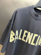 Navy Balenciaga short-sleeve top close-up with “BALENCIAGA” logo across chest