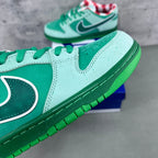 Low-top sneaker side view in seafoam suede with dark green swoosh and white stripe