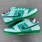 Two seafoam low-top sneakers with dark green swoosh, green soles, and red plaid accents