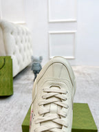 Unisex sneaker front in light color with lace-up closure and stitched panel details.