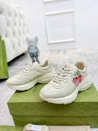 Unisex sneakers in light color with red logo patch on the side; chunky sole and laces.