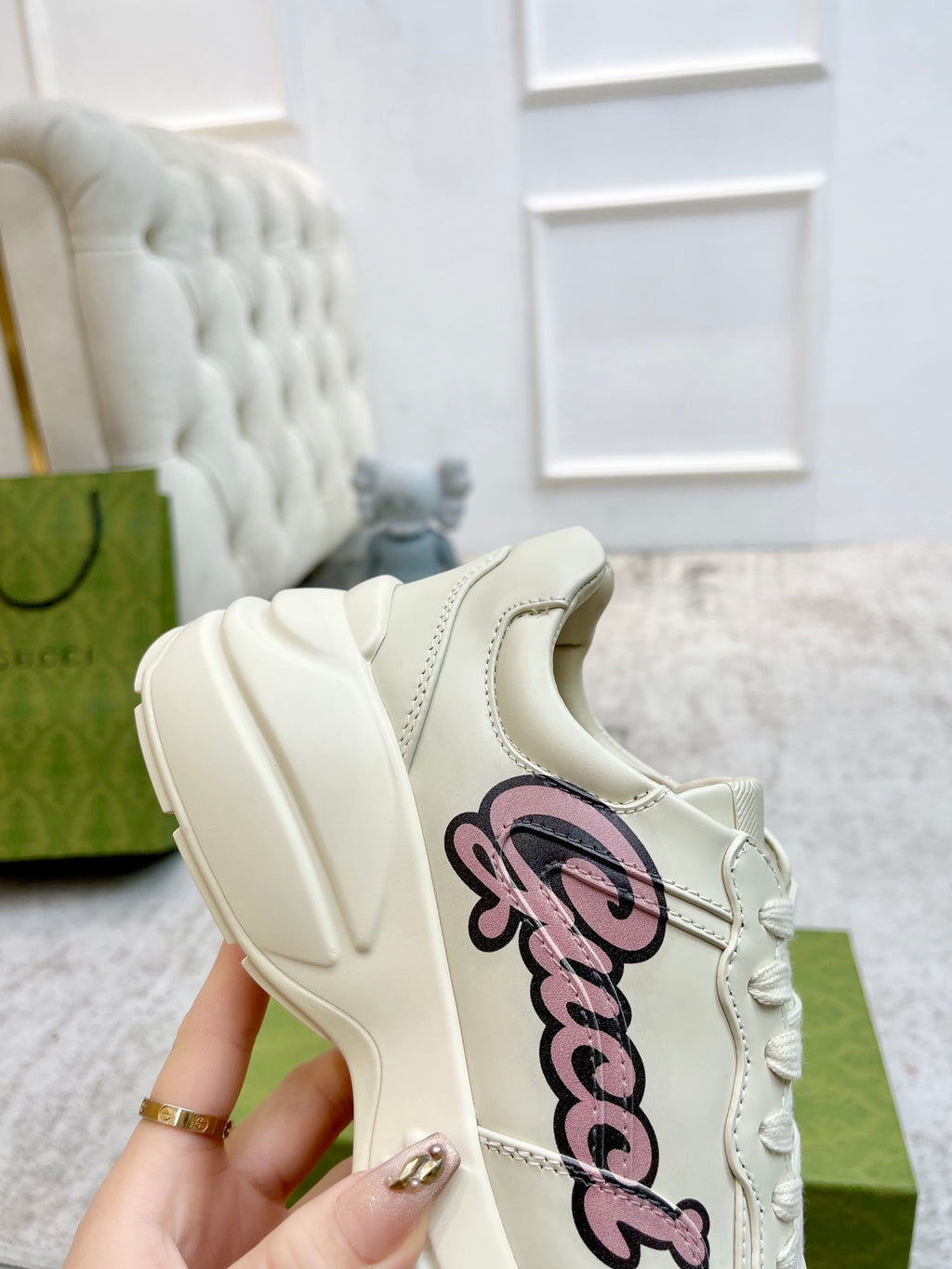 Gucci unisex sneaker, cream upper with pink script logo detail on the side