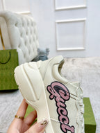Gucci unisex sneaker, cream upper with pink script logo detail on the side