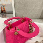 Pink quilted Dior handbag with top handle, gold hardware, and chain strap