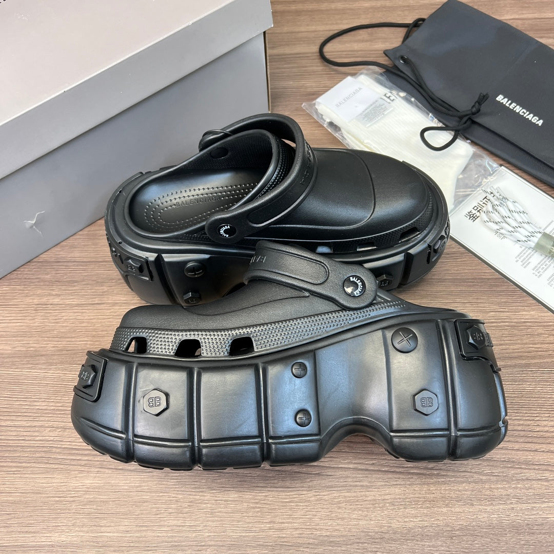 Clog-style sandals, side view with curved strap and perforated footbed, dark