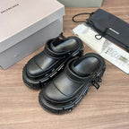 Clog-style sandals pair, angled view with adjustable strap and chunky outsole, dark