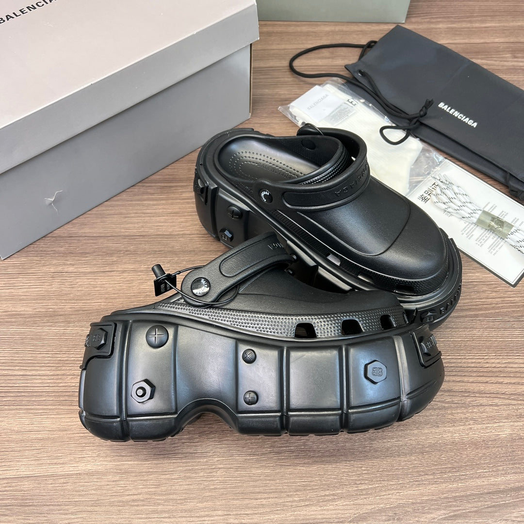 Clog-style sandals, three-quarter view with sculpted panels and perforations, dark