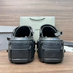 Clog-style sandals, heel view with BALENCIAGA logo on back, dark gray/black