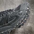 Balenciaga sneaker side panel with silver trim, black laces, and studded tread