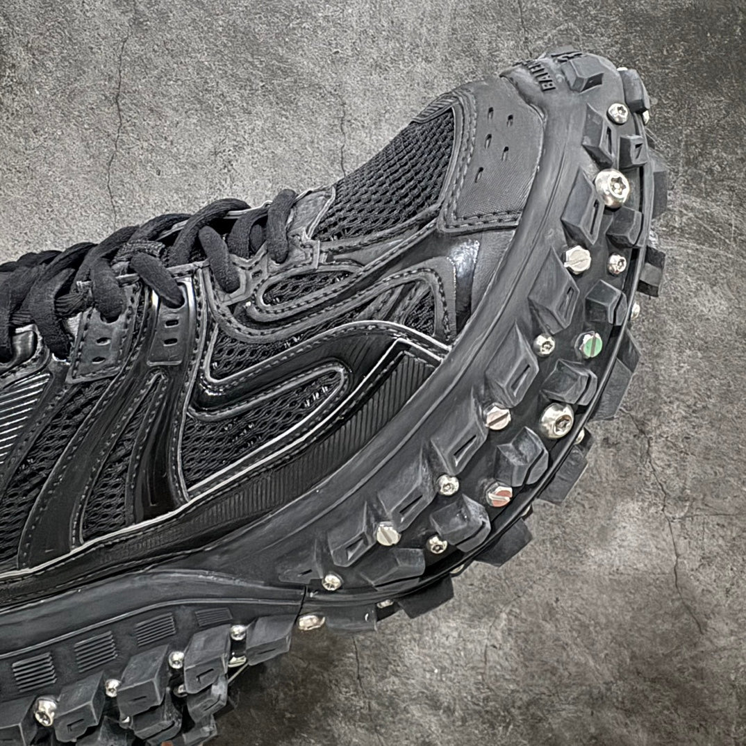 Balenciaga sneaker side panel with silver trim, black laces, and studded tread