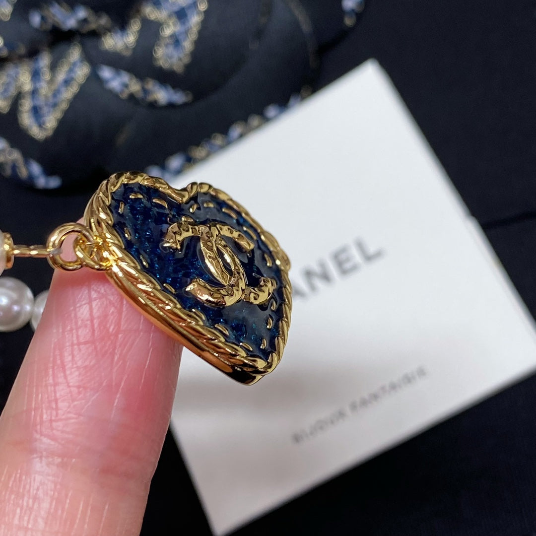 Blue heart charm pearl-bead bracelet close-up with gold side frame