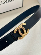 Dark leather belt close-up with gold CC-style buckle and pink stone trim