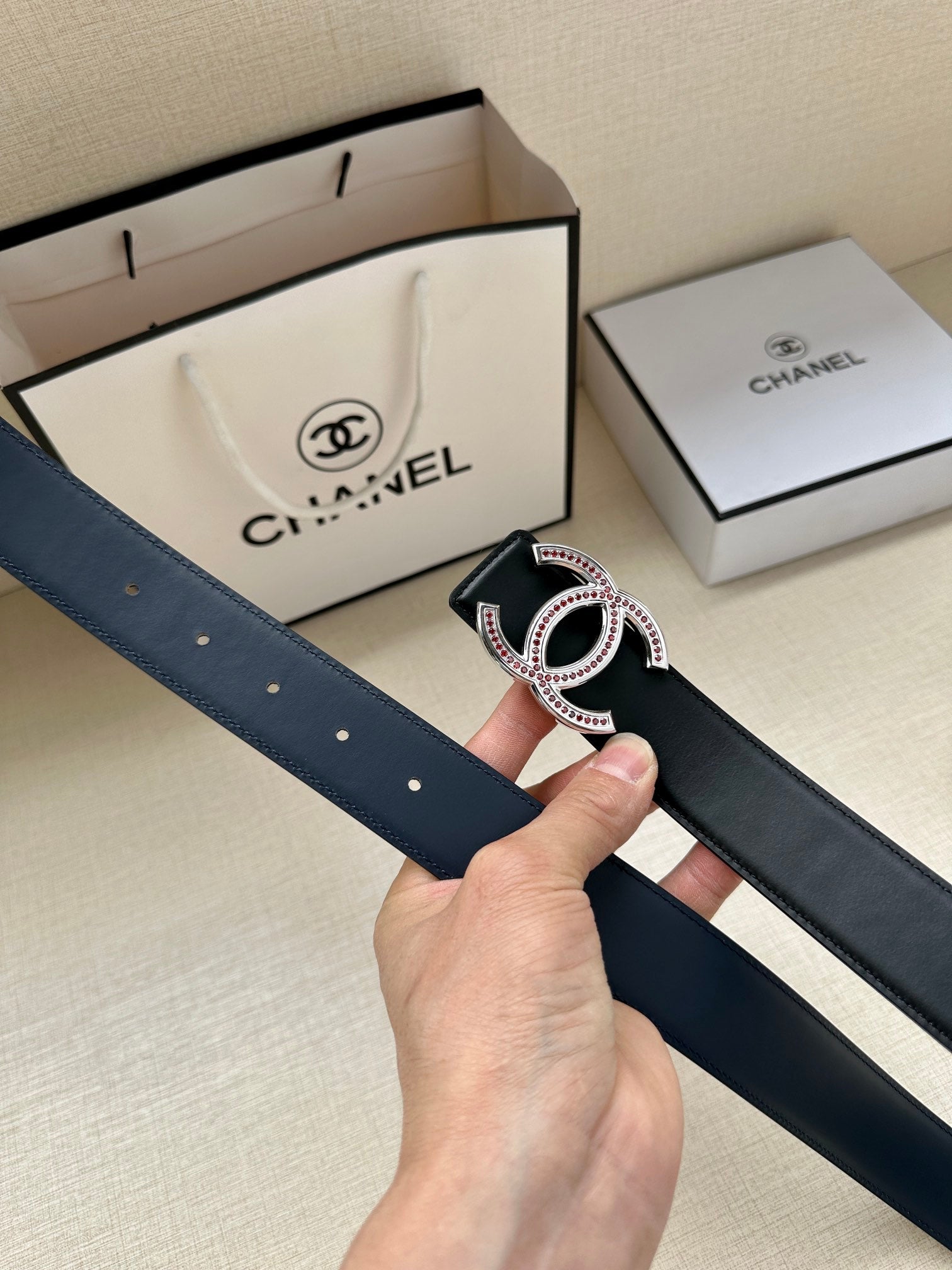 Dark leather belt with CC-style buckle and pink-and-clear stone border
