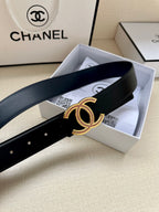 Dark leather belt with gold CC-style buckle and pink stone accents laid in box