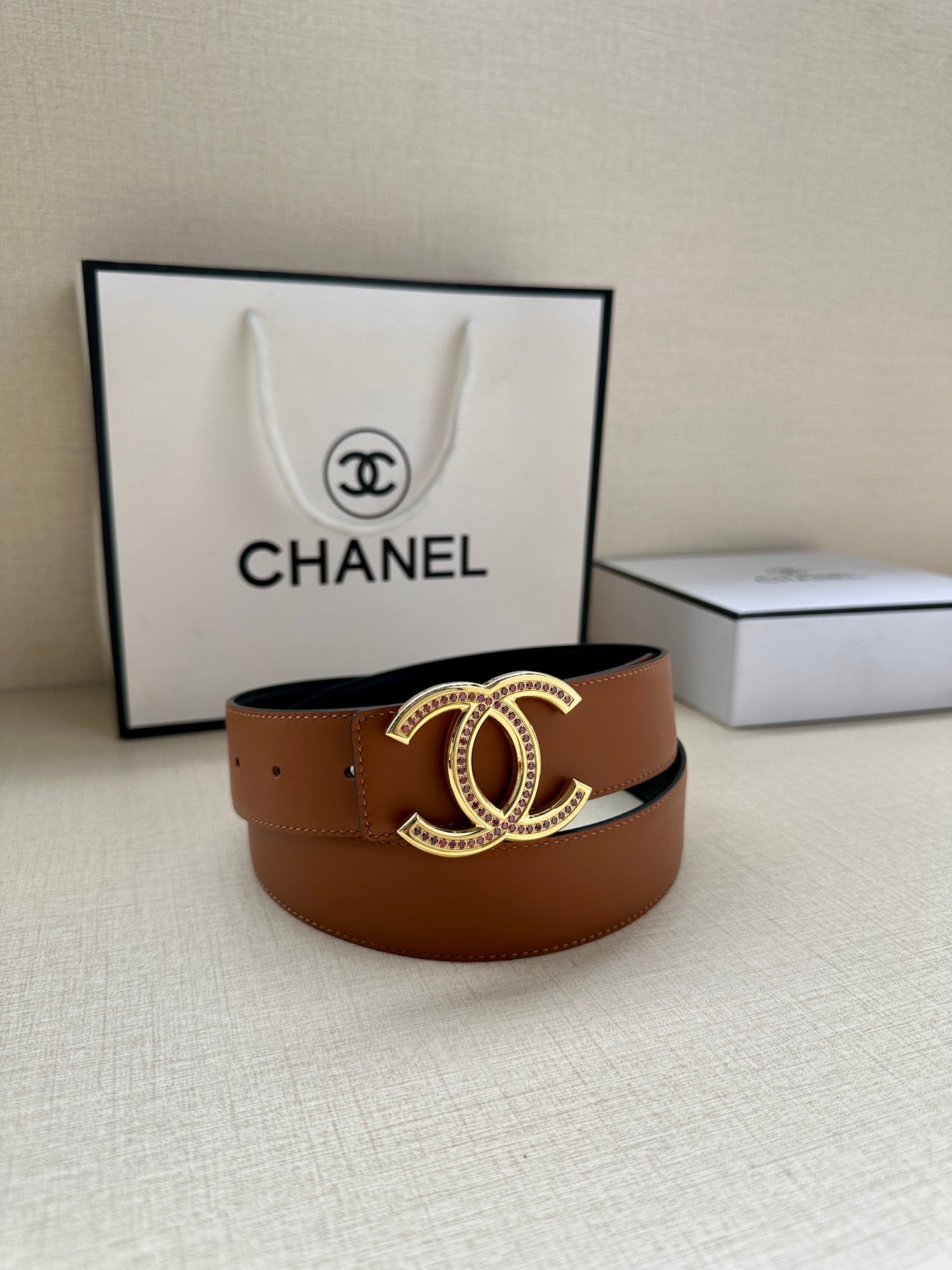 Brown wide leather belt with gold-tone double-C buckle at center.