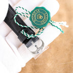 Rolex wristwatch buckle and strap end with green seal, silver clasp