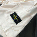 Off-white shorts with Stone Island logo patch on front pocket