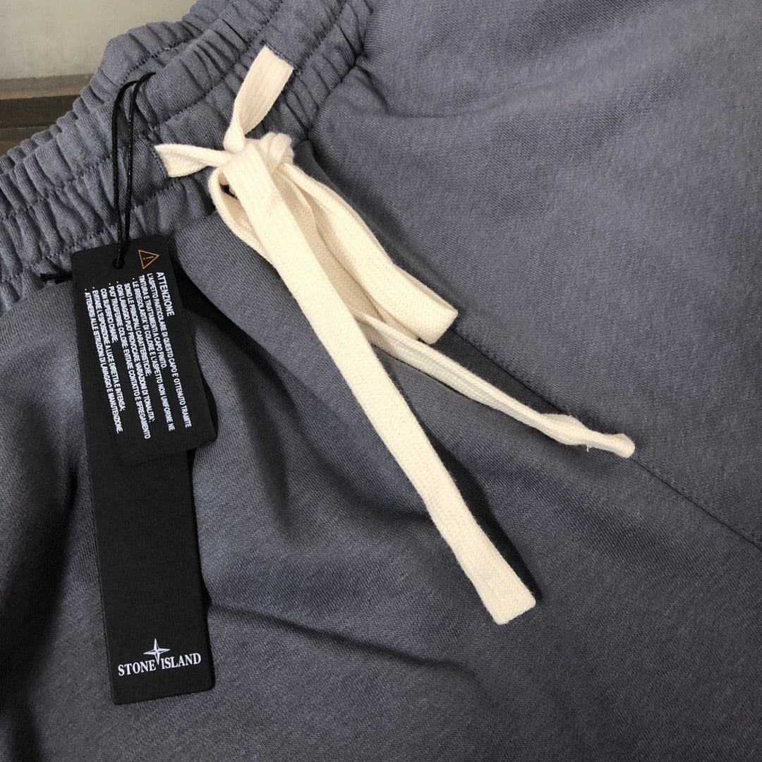 Stone Island shorts close-up with gray fabric, white drawstring, and black label