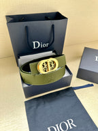 Green leather belt with gold-toned oval logo buckle and textured leather surface