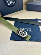 Green leather belt with silver-toned oval buckle and embossed logo segment
