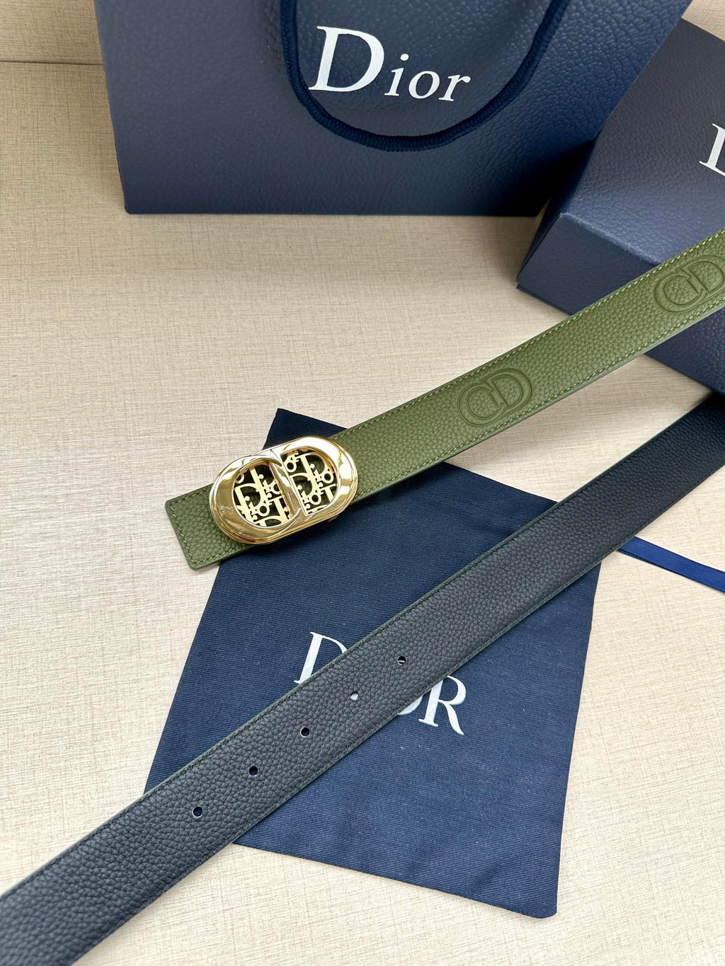 Green leather belt with gold-toned oval buckle and perforated adjustment holes