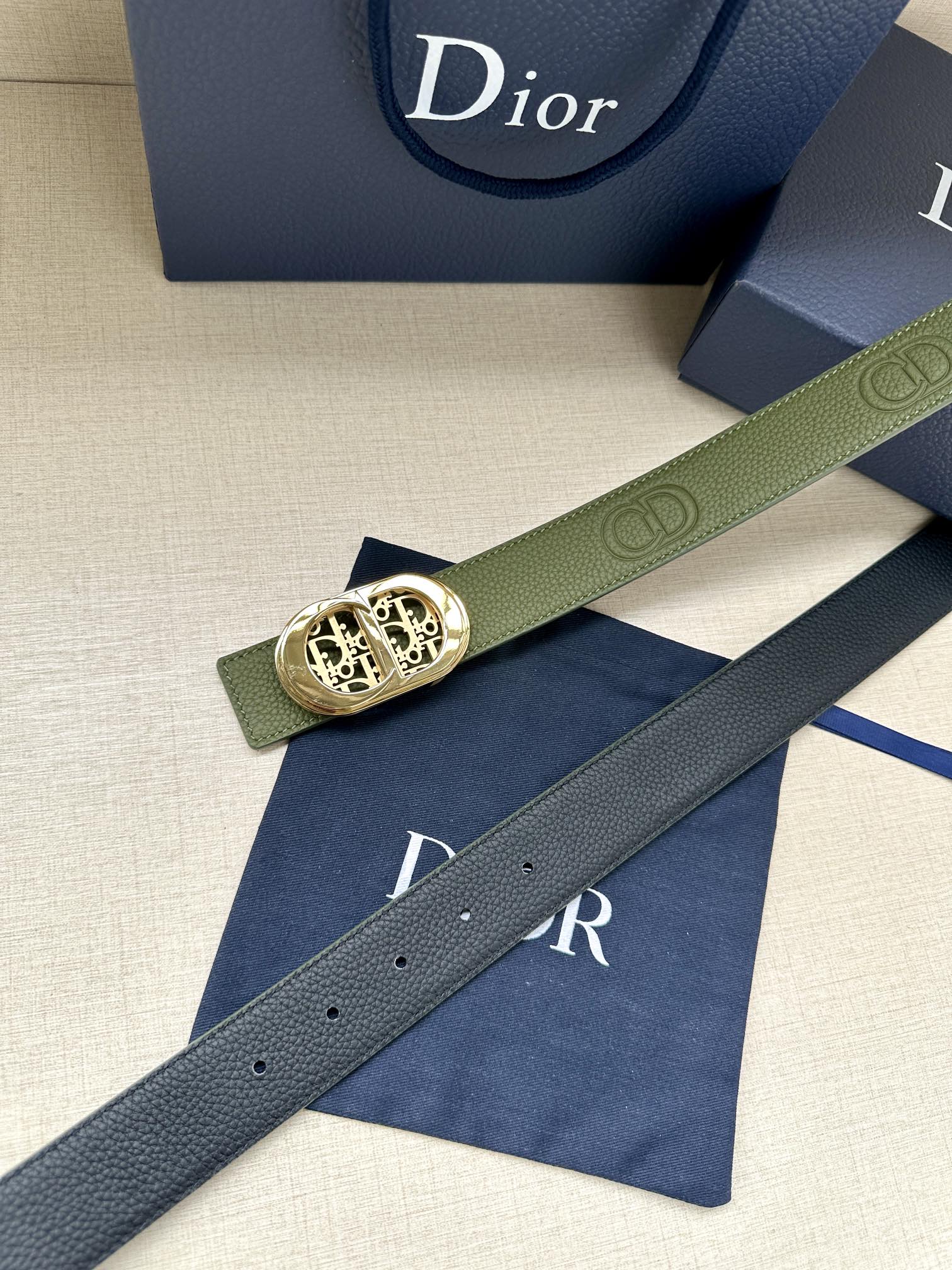 Green leather belt with gold-toned oval buckle and perforated adjustment holes
