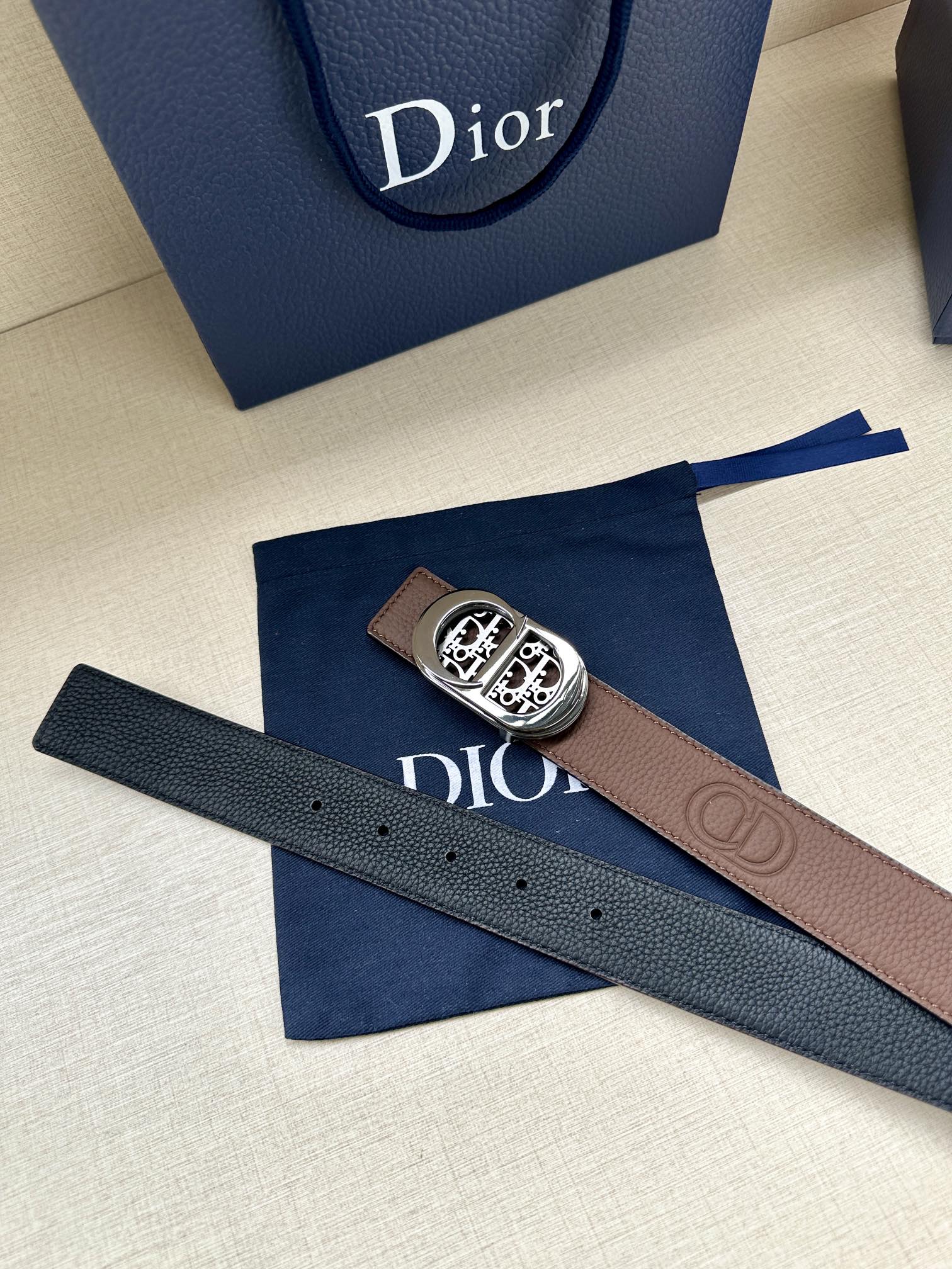 Dior leather belt with dark brown strap and silver buckle, side view