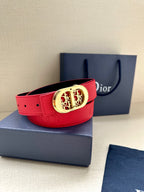 Red leather belt with gold-tone oval logo buckle and embossed strap design